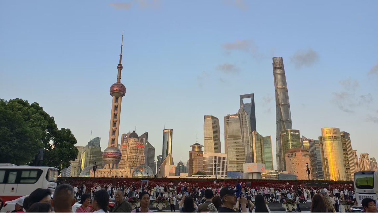 Shanghai’s Lujiazui skyline, with the Oriental Pearl Tower and Shanghai Tower above the riverside crowds